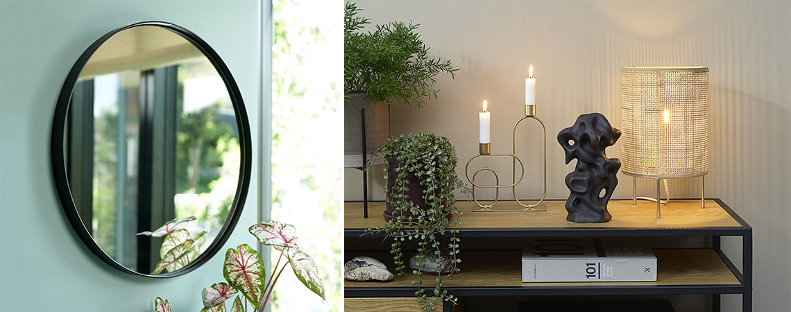 Miroir rond sur mur vert, petite lampe de décoration et bougie