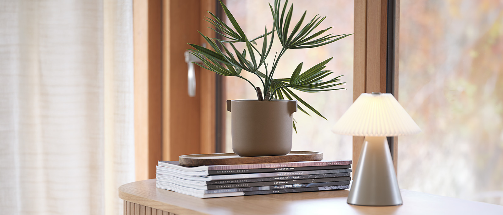 Ajoutez une touche de verdure sans entretien à votre intérieur Plante artificielle en pot sur un bureau avec des livres et une lampe de table