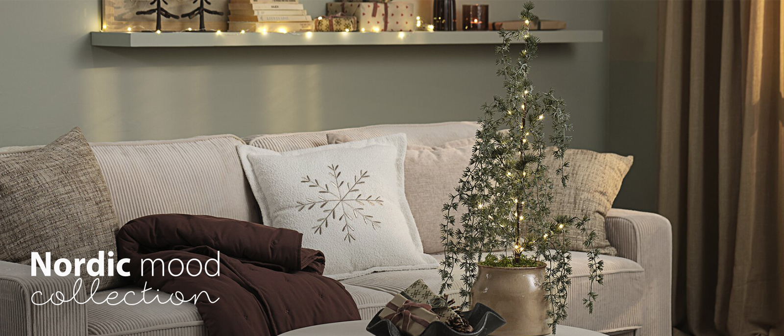 Canapé avec coussins et plaids dans un salon décoré pour les fêtes