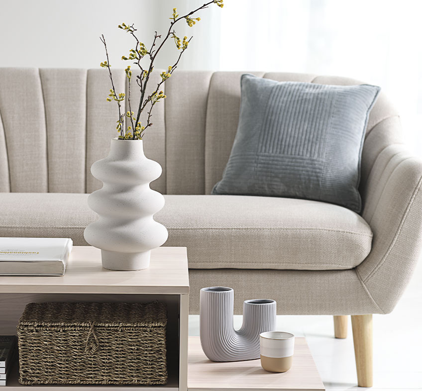 Vase AVLIS, vase TORMUND et tasse FREDERIK Salon lumineux avec vases ludiques sur une table basse et canapé beige
