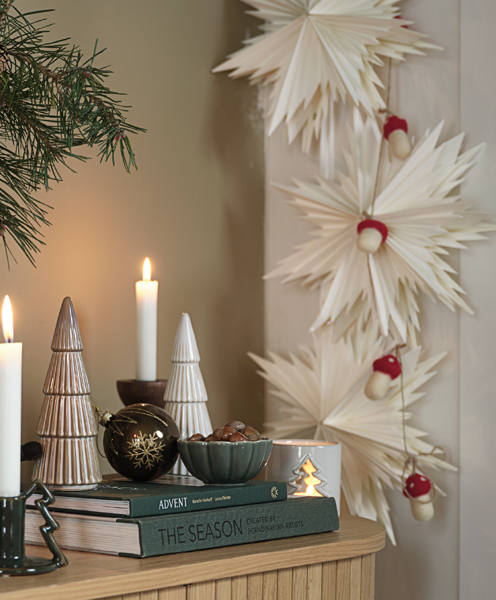 Guirlande LODUR avec champignons en feutrine Un buffet avec d'élégantes décorations de Noël et des étoiles en papier sur le mur