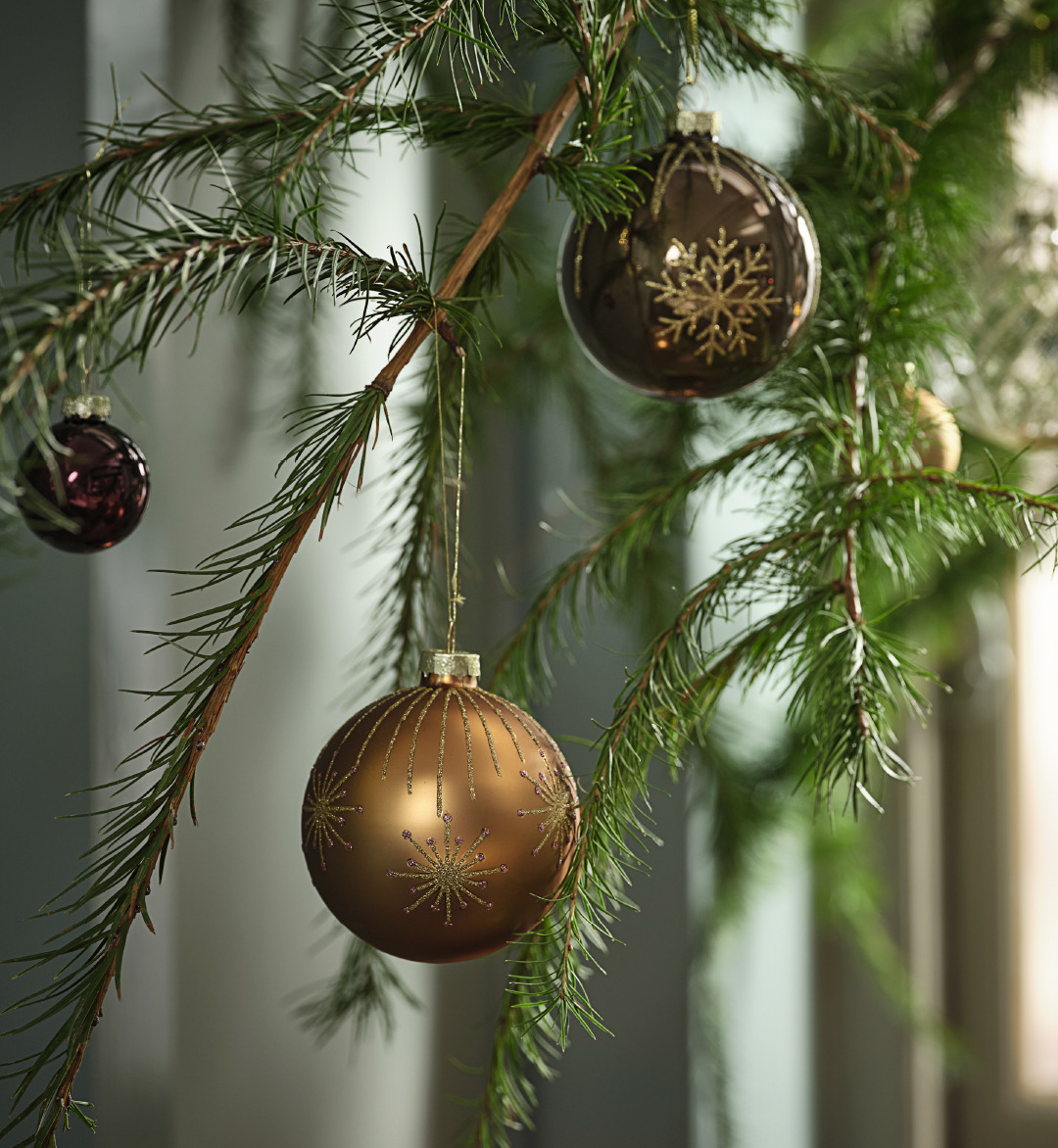 Boules de Noël GALDER scintillantes Une branche de sapin décorée avec des boules dans des tons bruns scintillants