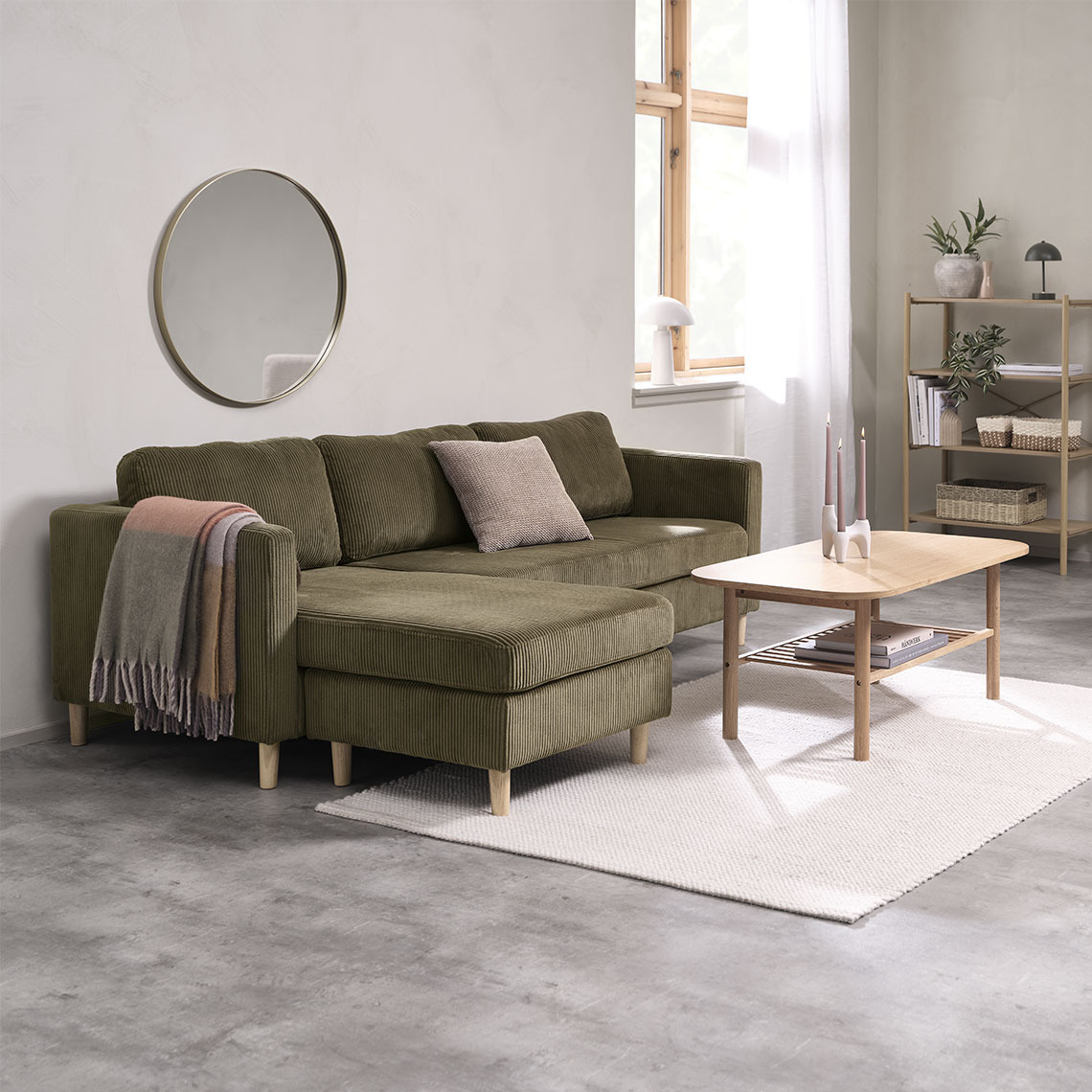 FALSLEV chaise lounge sofa Olive green chaise lounge sofa with a coffee table and a colourful throw and cushion