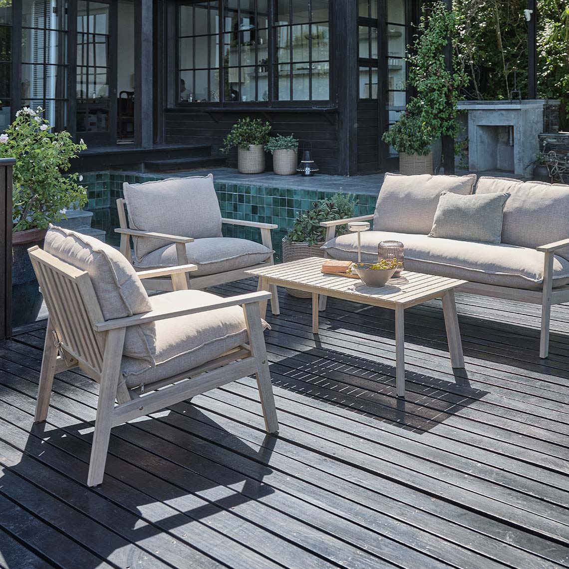 Ensemble lounge d'extérieur comprenant un canapé, deux fauteuils et une table basse en acacia massif huilé blanc. 