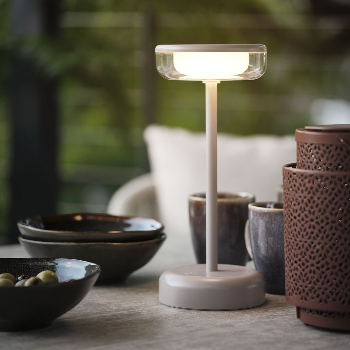 Lampe de table d'extérieur HUMLEBI à piles Lampe de table à piles sur une table de jardin avec des bols et des mugs