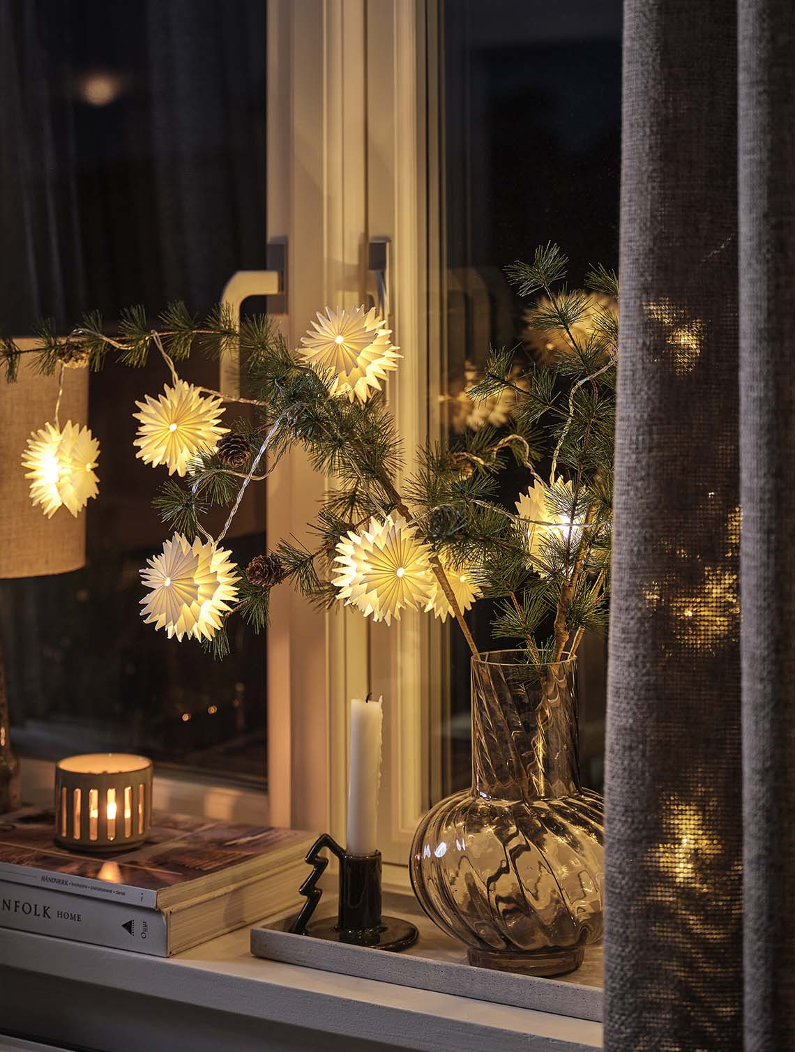 Guirlande lumineuse PLATIN en forme d’étoile avec minuterie intégrée Guirlande lumineuse en forme d'étoile disposée sur des branches de sapin dans un vase illuminant un rebord de fenêtre la nuit