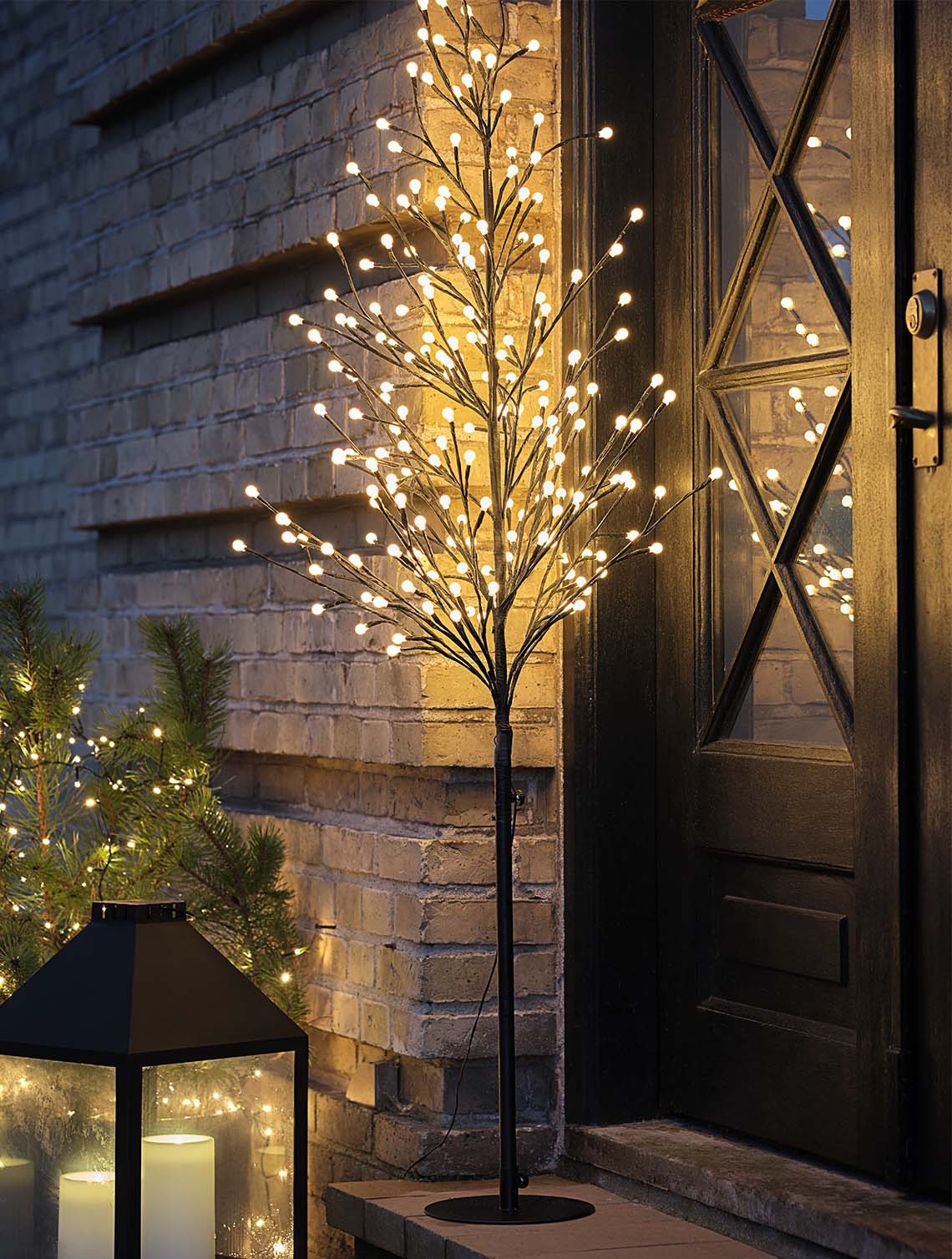 Arbre lumineux NUNDORIT avec minuteur intégré Arbre lumineux illuminant la porte d'entrée d'une maison pendant la nuit