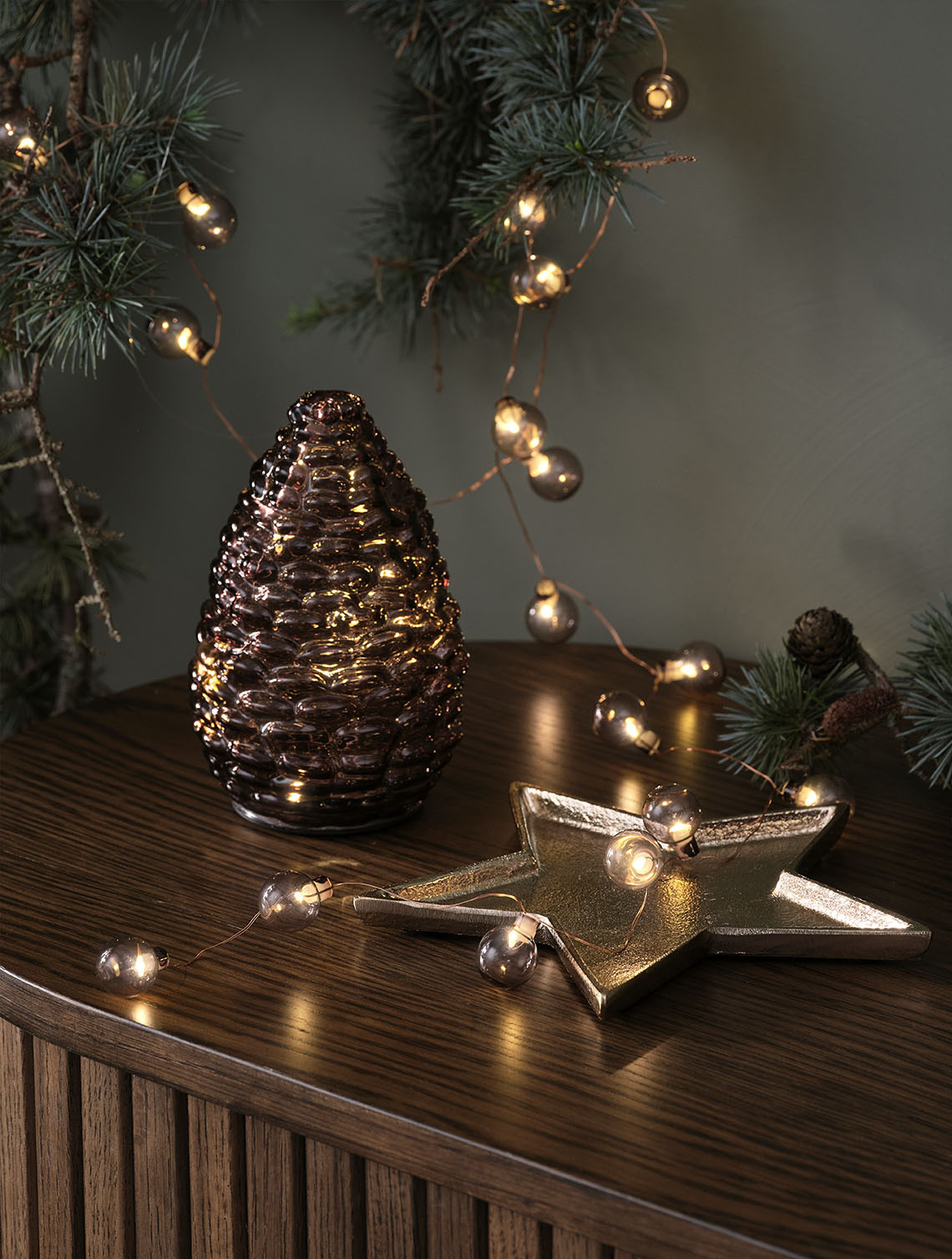 Cône DELLING et guirlandes lumineuses ALV Éclairage décoratif de Noël, tel qu'une pomme de pin en verre et une guirlande lumineuse dorée sur le dessus d'un buffet