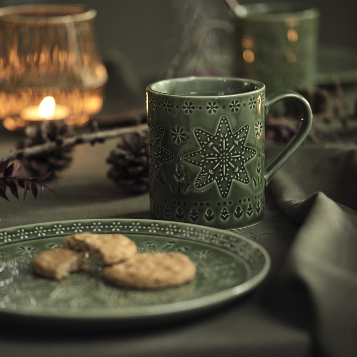table Une assiette de Noël verte et un mug sur une table