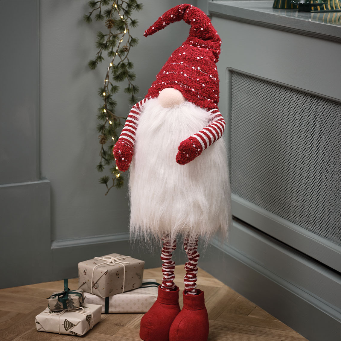 Grand lutin de Noël avec un bonnet rouge et une grande barbe