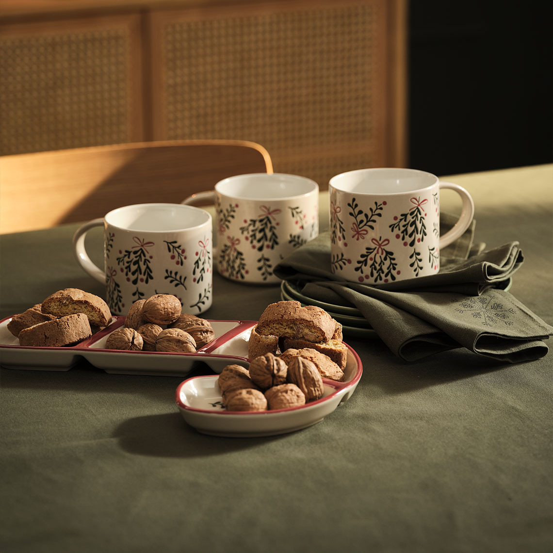 Tasses, bol et serviettes en tissu de Noël sur une table