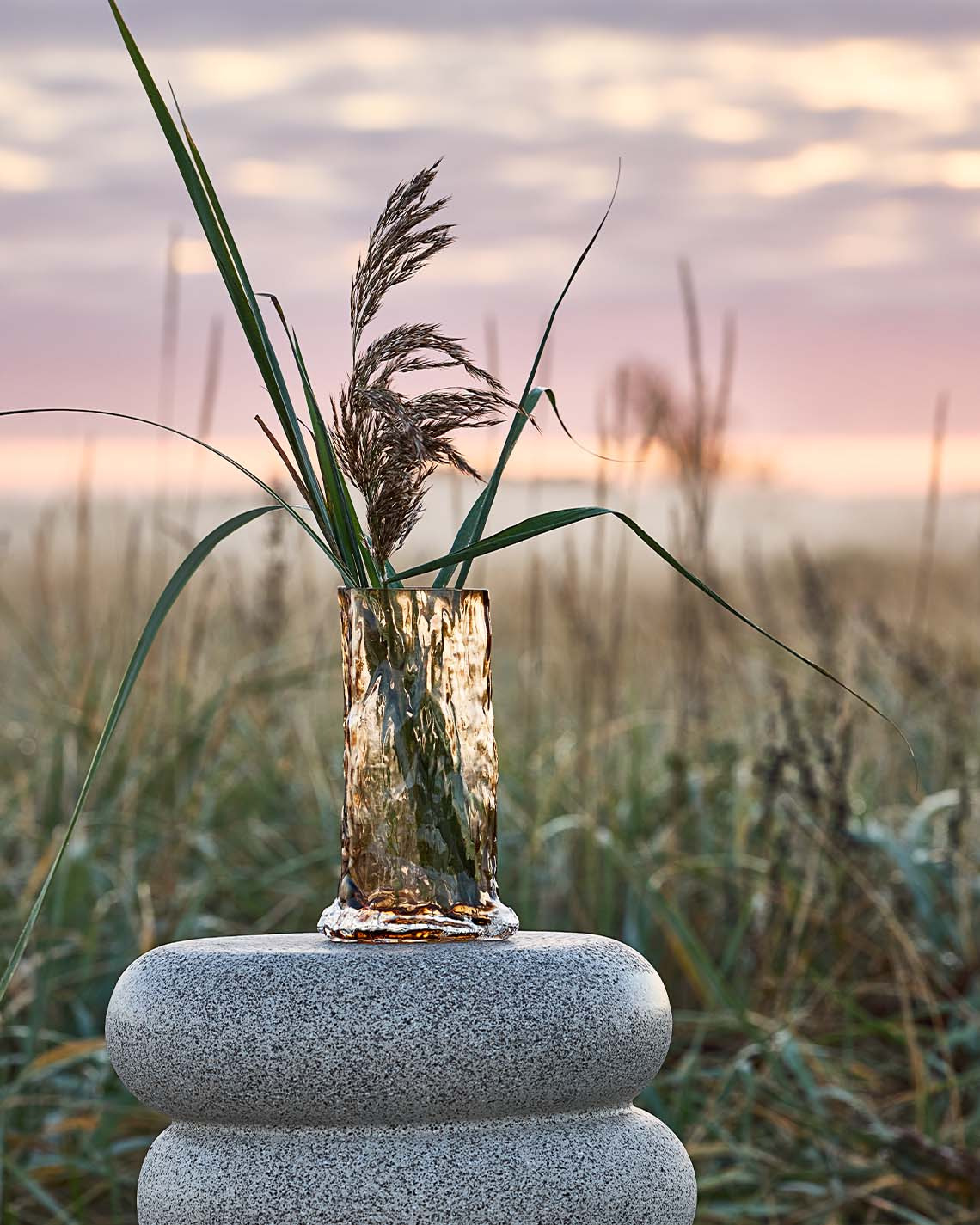 Grand vase sur piédestal dans les dunes près d'une plage