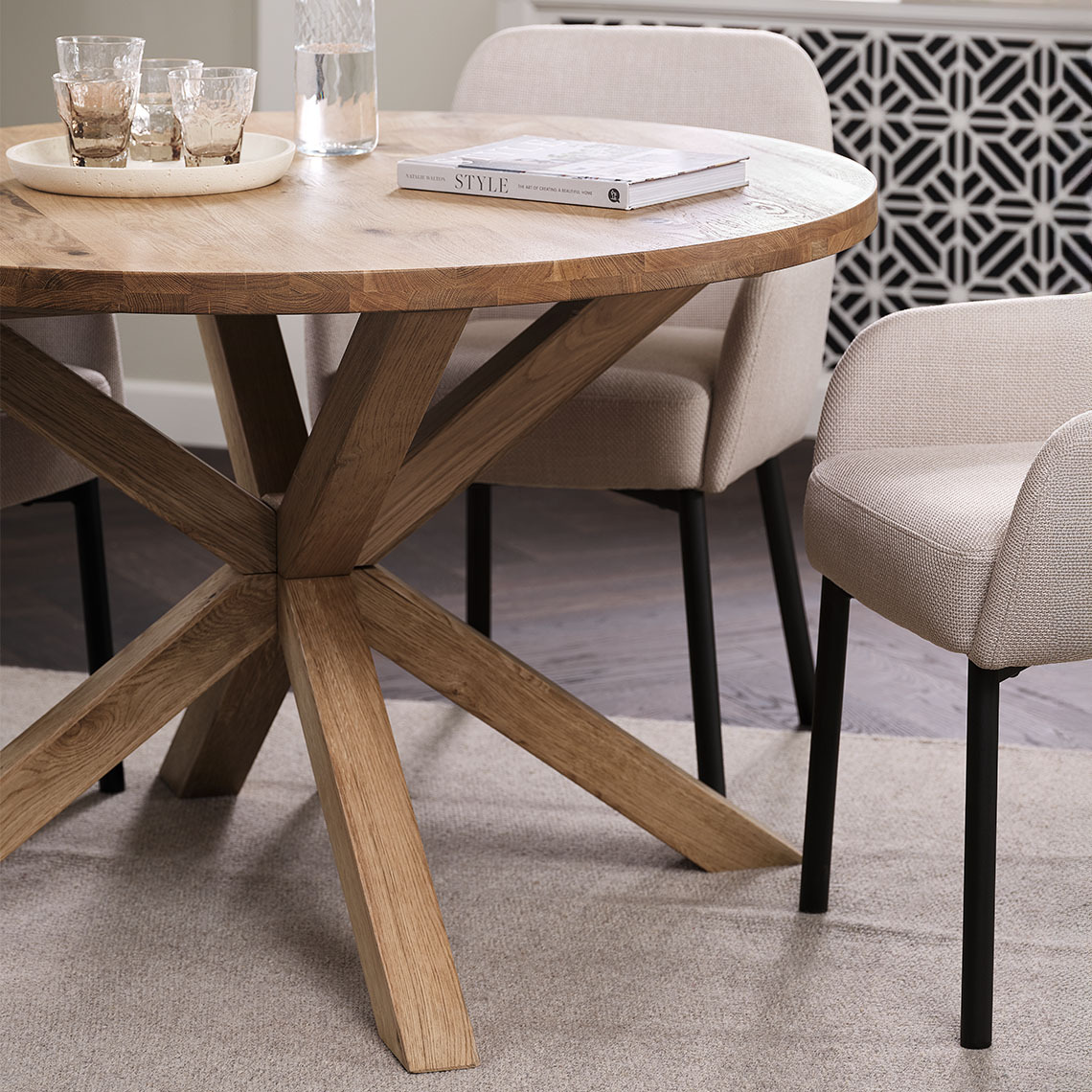 Round FSC solid oak dining table in dining area with beige dining chairs 