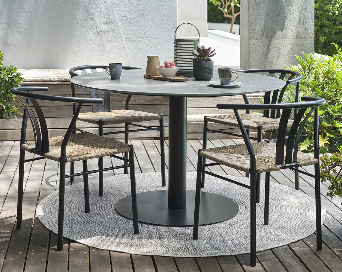Table de jardin en gris VAMDRUP et chaises de jardin TAGMARK Table de jardin sur pied central avec quatre chaises de jardin sur une terrasse