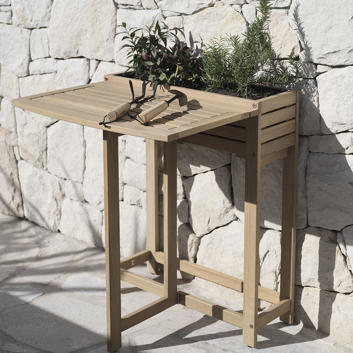 Table pliante en bois massif avec jardinière intégrée, placée sur une terrasse.