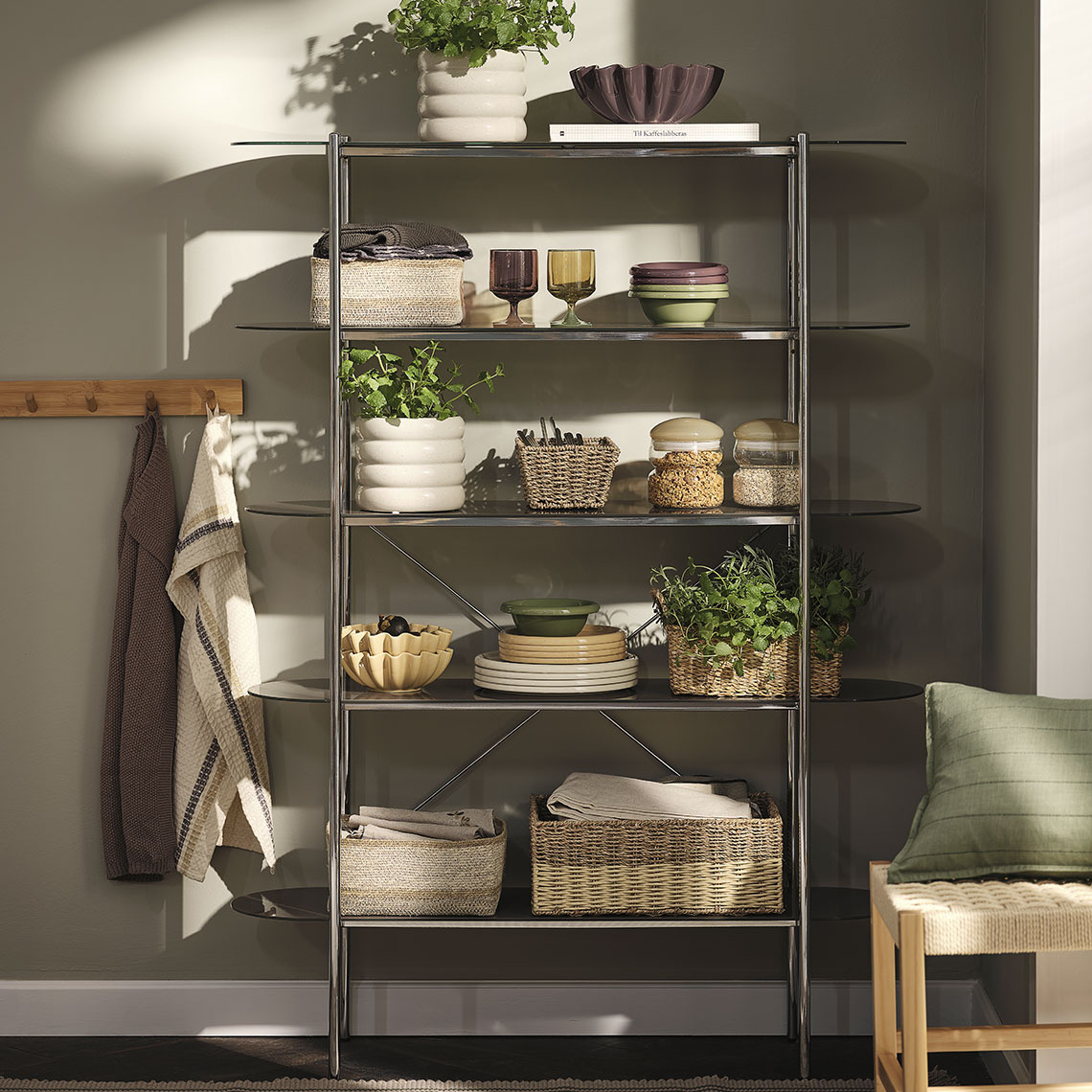 Couverts GREGERS, assiettes et bols MALIK, verres ISAK, panier FILIP, bocaux de conservation DAHL, torchons BARLIND, housses de coussin POPPEL, torchons TISTEL, bols NOR Des verres, assiettes et bols colorés, des paniers et des bocaux de rangement sur une étagère