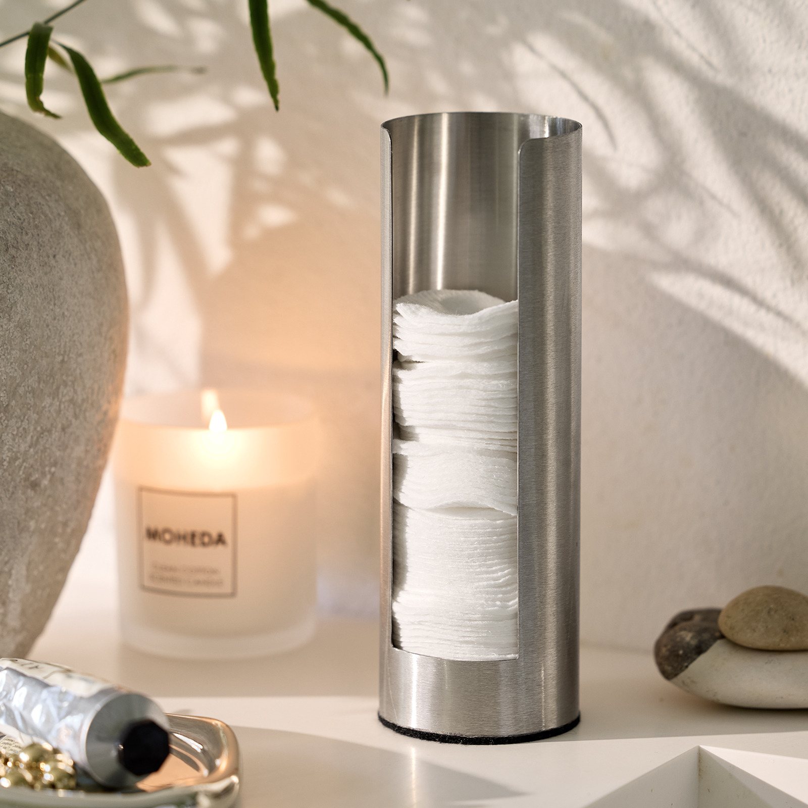 Distributeur de coton et bougie parfumée dans une salle de bain