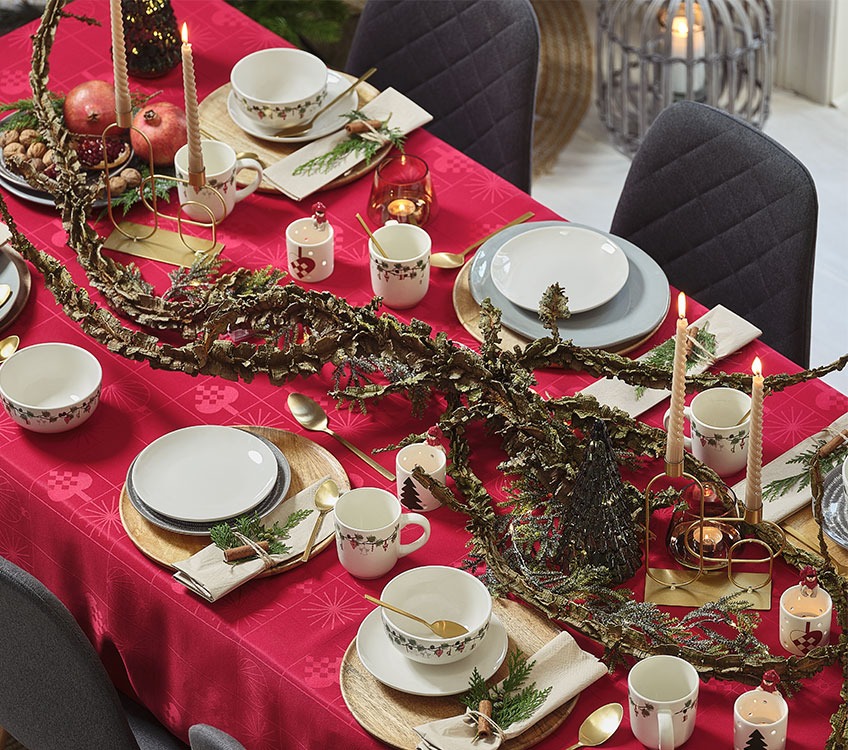 Nappe GULDSTEN, vaisselle HORNBLENDE et photophore SKINFAXE Table de Noël avec une nappe rouge et vaisselle dorée