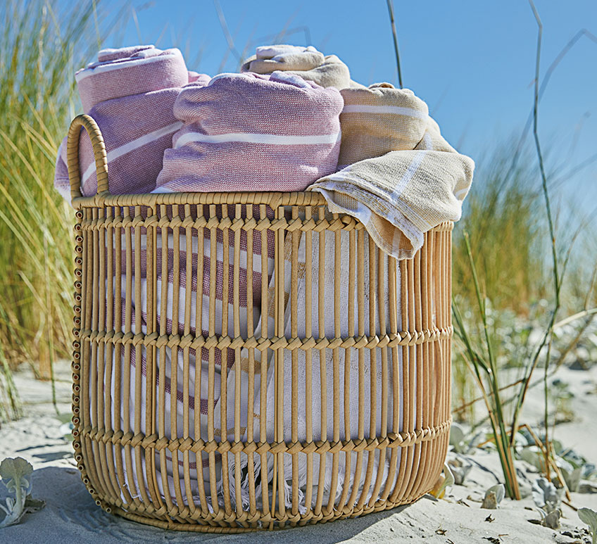 Panier ALVAR avec serviettes de plage BACKA Un grand panier avec des serviettes sur une plage